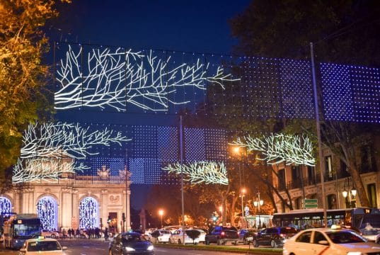 Puerta de Alcalá lit up for Christmas with Alcalá Street and traffic