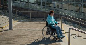 Madrid en silla de ruedas: balance en 2025 de la accesibilidad para personas con discapacidad de movimiento Mujer en silla de ruedas junto a escalera